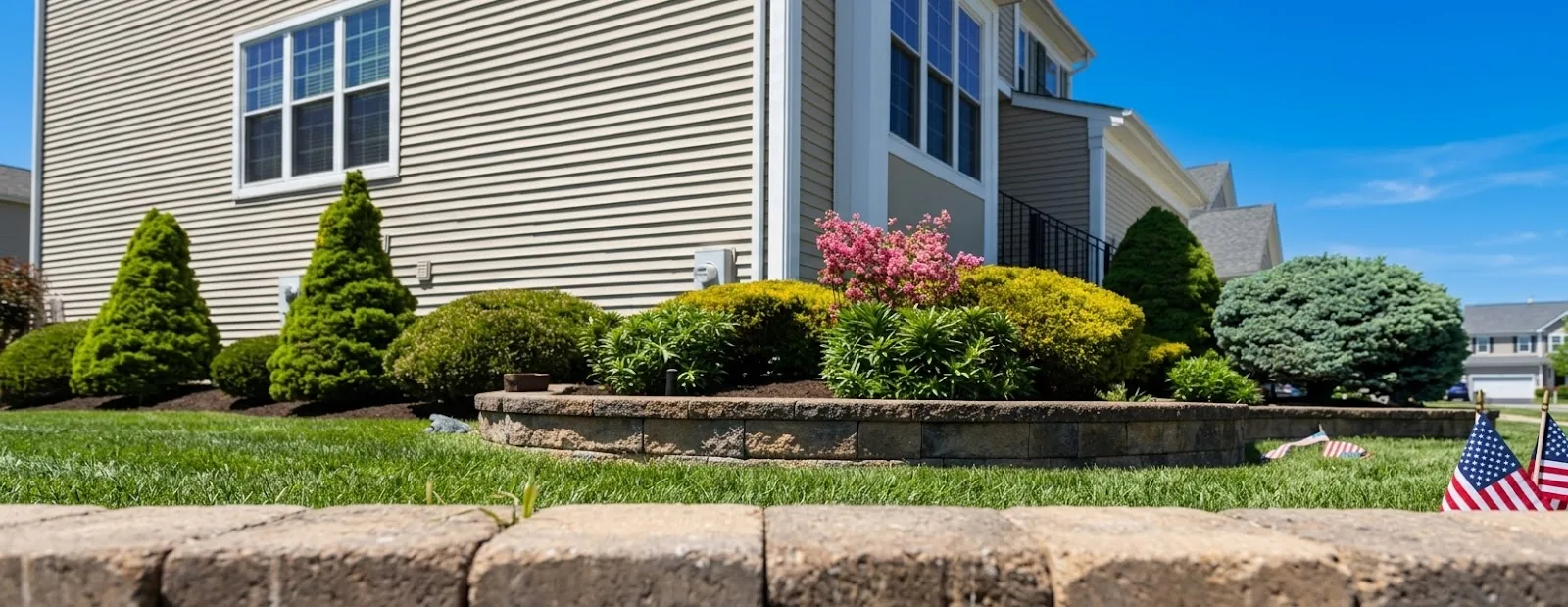 Alfano landscape with a stone garden wall, shrubs, flowering plants and lawn